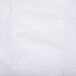 A close up of a Chef Revival white chef coat with a button.