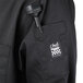 A close-up of a black Chef Revival chef jacket with a customizable chest pocket.