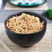 A Libbey stoneware bowl filled with noodles on a table with chopsticks.