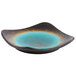 A blue and black Libbey stoneware plate with round detailing on a table.