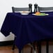 A table with a navy blue Intedge tablecloth and a plate of food.