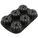A close-up of a black Chicago Metallic bundt cake pan with six mini cakes.