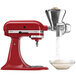A red KitchenAid stand mixer with a bowl of flour underneath.