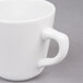 A close up of a Bright White Tall Porcelain Coffee Cup with a handle.