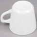 A close-up of the handle of a white porcelain coffee cup.