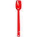 A red plastic salad bar spoon with a white background.
