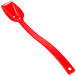 A red plastic spoon with a long handle.