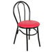 A black metal Lancaster Table & Seating hairpin chair with a red vinyl seat.