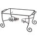 A black wrought iron American Metalcraft chafer stand on a table outdoors.