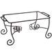 An American Metalcraft wrought iron chafer stand on a glass table with metal bowls.
