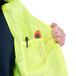 A man wearing a Cordova lime high visibility safety vest with a pocket and a pen in it.