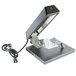 A black and silver Bron Coucke round cheese raclette machine with a black cord.