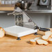 A Tellier bread slicer on a table with sliced bread.