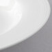 A close up of a white porcelain pasta bowl with a white rim.