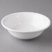 A Reserve by Libbey Aluma White Porcelain Grapefruit Bowl on a gray surface.