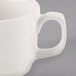 A close up of a Libbey ivory porcelain mug with a handle.