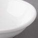 A close-up of a white Reserve by Libbey Aluma White Porcelain Fruit Bowl with a white rim.