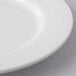 A close-up of a Reserve by Libbey Aluma White Porcelain Plate with a white rim.