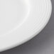 A close-up of a white Reserve by Libbey porcelain plate with a circular pattern on the rim.