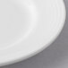 A close-up of a white Reserve by Libbey Aluma porcelain plate with a rim.