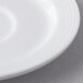 A close-up of a white Libbey Aluma Stacking Saucer with a rim.