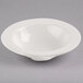 A Libbey ivory porcelain grapefruit bowl on a gray surface.