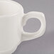 A close up of a Libbey ivory porcelain small stacking cup with a handle.