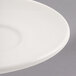 A close up of a Libbey ivory porcelain small saucer with a white rim.