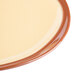 A close-up of a Libbey Terracotta mustard yellow stoneware plate with a rim.