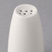 A close-up of a Libbey ivory porcelain salt shaker with holes.