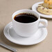 A cup of coffee on a Reserve by Libbey Aluma White porcelain tea saucer.
