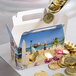 A white Landscape Window Candy Box filled with gold coins.
