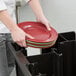 A person using a Cambro Versa Black Dish Caddy to carry a stack of plates.