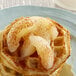 A white plate with a waffle topped with Regal sliced pears in light syrup.