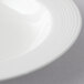 A close-up of a white porcelain soup bowl with a white rim.
