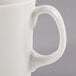 A close up of a Libbey ivory porcelain cafe mug with a handle.