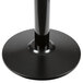 A Lancaster Table & Seating black cast iron round table base with a black metal pole and round base.