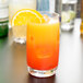 A Chef & Sommelier Cabernet beverage glass filled with orange juice and garnished with a slice of orange.