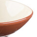 A close up of a Libbey terracotta bowl with a brown and white rim.