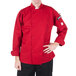 A person wearing a Mercer Culinary red chef coat.