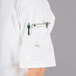 A white Mercer Culinary Millennia cook jacket with a pen in the pocket.