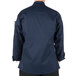 The back of a person wearing a Mercer Culinary Millennia navy cook jacket.