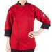 A woman wearing a Mercer Culinary red chef coat with 3/4 length sleeves.