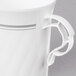 A white plastic coffee mug with a handle and silver accents.