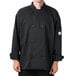 A man wearing a Mercer Culinary black chef coat with a full mesh back.