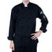 A man wearing a Mercer Culinary black chef jacket with knot buttons.