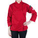 A woman wearing a red Mercer Culinary Millennia chef coat with long sleeves.