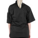 A woman wearing a black Mercer Culinary chef jacket with short sleeves.