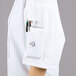 A person wearing a Mercer Culinary white short sleeve chef coat with a full mesh back.