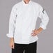 A man wearing a white Mercer Culinary Millennia long sleeve chef jacket.